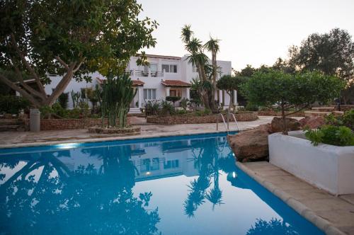 a swimming pool in front of a house at Apartamentos Vista Vedrá in La Savina