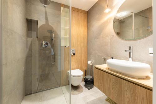 a bathroom with a toilet and a sink and a shower at Victus Apartamenty, Apartament Malta in Sopot