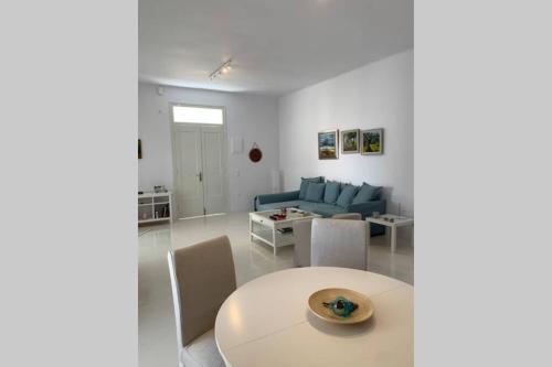 a living room with a table and a blue couch at Ευημερία in Andros