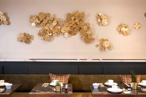 a dining room with tables and a wall with wine corks at Hôtel Aiglon in Paris