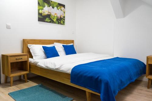 a bedroom with a bed with blue and white pillows at English House in Bistriţa