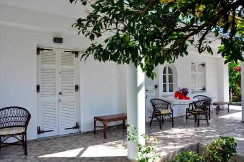 - un groupe de chaises assises autour d'une table dans une cour dans l'établissement Villa Elena Studios, à Dassia