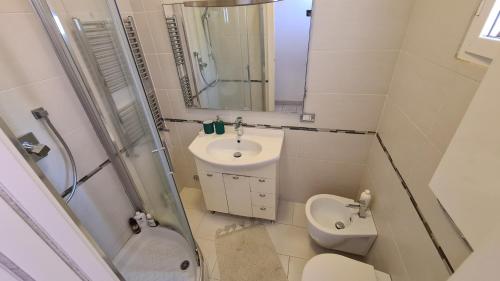 a bathroom with a sink and a toilet and a mirror at Ladispoli Apartment in Ladispoli