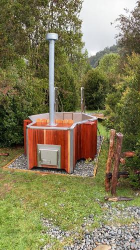 a stove that is sitting in the grass at Rincón del Gaucho in Hornopiren