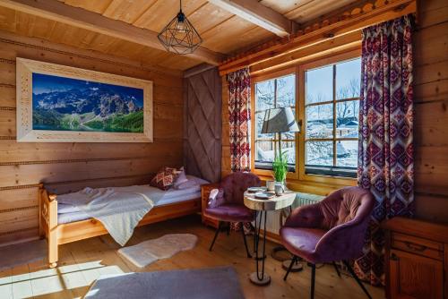 una camera da letto con un letto, due sedie e una finestra di Willa Pod Niebem a Zakopane