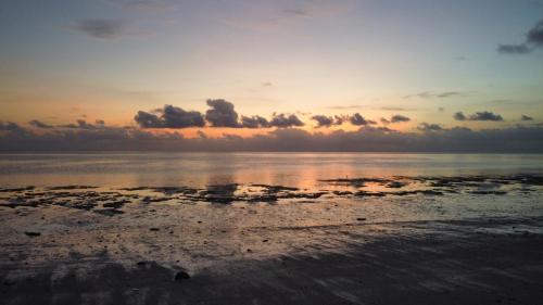 a sunset on a beach with the water at VRclub Paje Palms Beach Resort in Paje