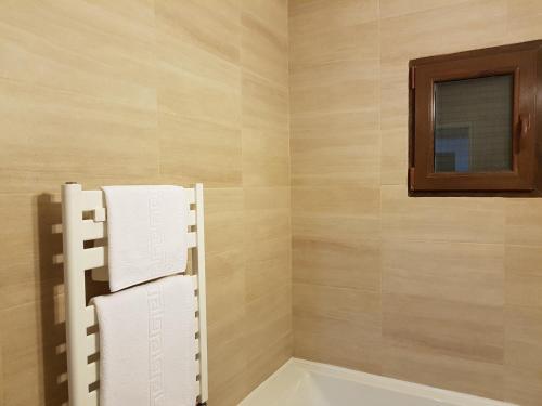 a bathroom with a tub and a mirror and towels at Mary Apartment in Galaţi