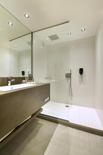 a bathroom with a shower and a sink and a mirror at Hotel Charleroi Airport - Van Der Valk in Charleroi