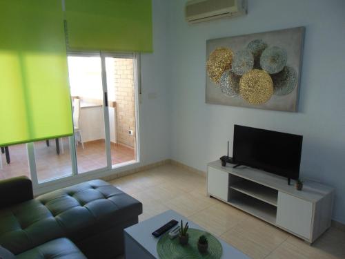 a living room with a couch and a flat screen tv at Apartamentos varios con 2 dorm en Marina Dor , la playa de Amplaries 47 , vista lateral al mar in Oropesa del Mar