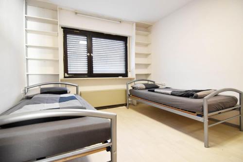 2 lits dans une chambre d'hôpital avec fenêtre dans l'établissement Work and Stay Apartment in Troisdorf, à Troisdorf