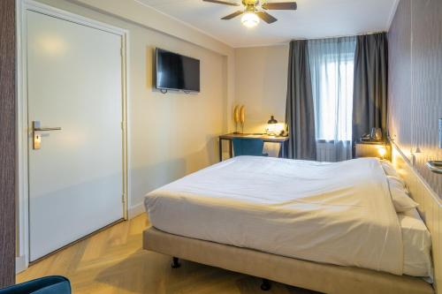 a bedroom with a bed and a tv and a door at Fletcher Hotel-Restaurant de Korenbeurs in Made