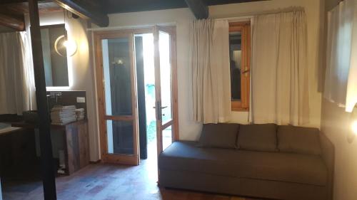 a living room with a couch and some windows at Villa Ca' Viola Rimini in Rimini