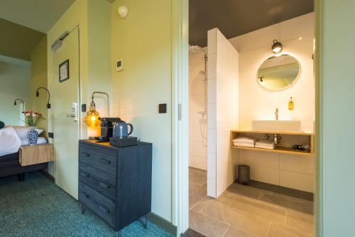 a bathroom with a sink and a vanity with a mirror at LUDIEK eten en slapen in Havelte