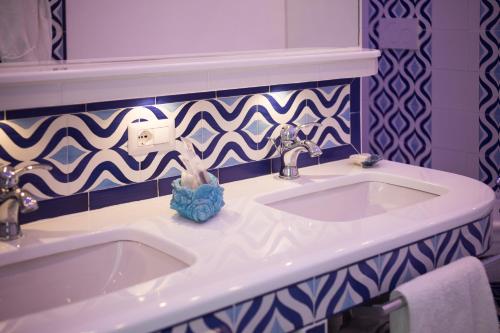 a bathroom with a white sink and blue and white tiles at Villa Fiorentino in Positano