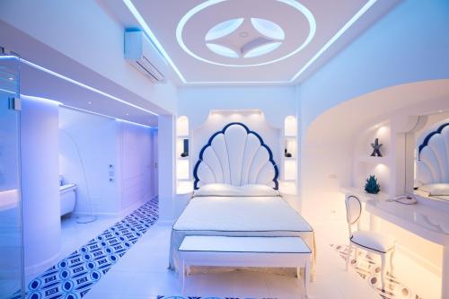 a bedroom with a white bed and a bathroom at Villa Fiorentino in Positano