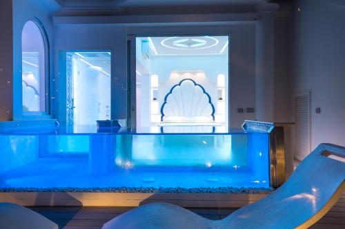 a large blue aquarium in a room with a chair at Villa Fiorentino in Positano