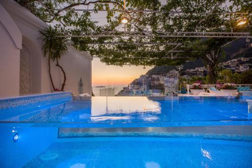 a large blue pool with a view of a city at Villa Fiorentino in Positano