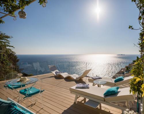 a deck with lounge chairs and a view of the ocean at Villa Fiorentino in Positano