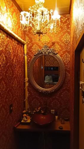 a bathroom with a mirror and a sink at Ryokan La Luna in Ukusu
