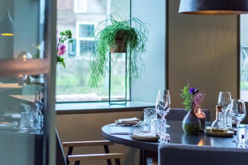 a table in a restaurant with glasses and a window at LUDIEK eten en slapen in Havelte