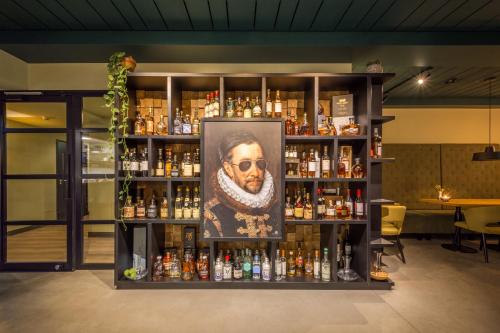 a bar with a portrait of a man on a shelf at LUDIEK eten en slapen in Havelte