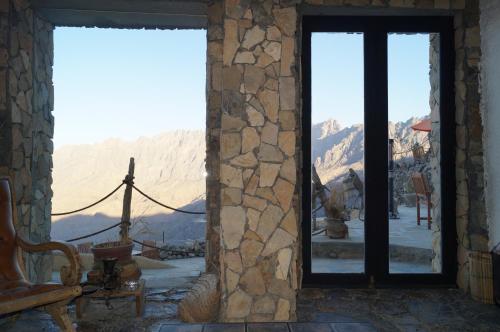 a room with a view of the mountains through windows at SAMA Wakan Heritage Homes in Fanjah