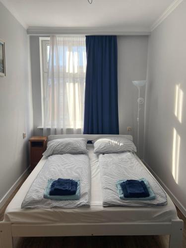 ソポトにあるBaltic Bay apartmentのベッド1台(窓の前に青いタオル2枚付)