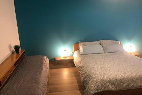 - une chambre avec un grand lit et deux lampes dans l'établissement La Maison Bleue Sul Naviglio, à Corsico