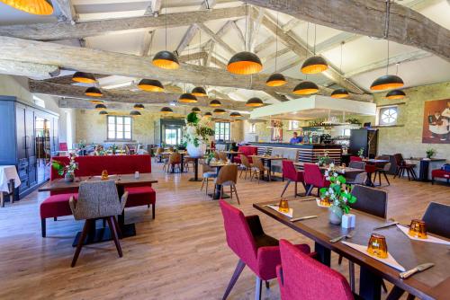un restaurant avec des tables en bois et des chaises rouges dans l'établissement Relais des Vigiers, à Monestier