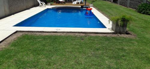 a small swimming pool with a fire hydrant in the grass at Casa Quinta en Luján - Olivera in Olivera