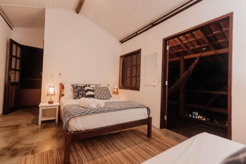 una camera con un letto e una grande finestra di Onda´s Caraíva a Caraíva