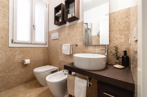 a bathroom with a white sink and a toilet at Casa Bembo in Asolo