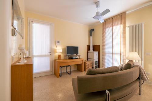 a living room with a couch and a desk with a television at Casa Bembo in Asolo