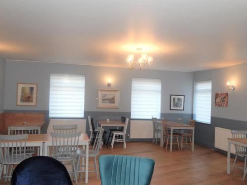 a dining room with tables and chairs and windows at The Saxon Inn in Bishop Auckland