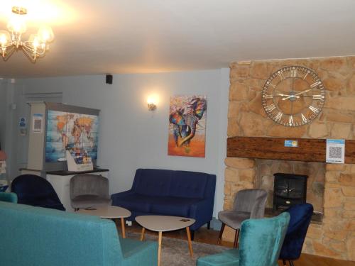 a living room with a stone fireplace and a clock at The Saxon Inn in Bishop Auckland