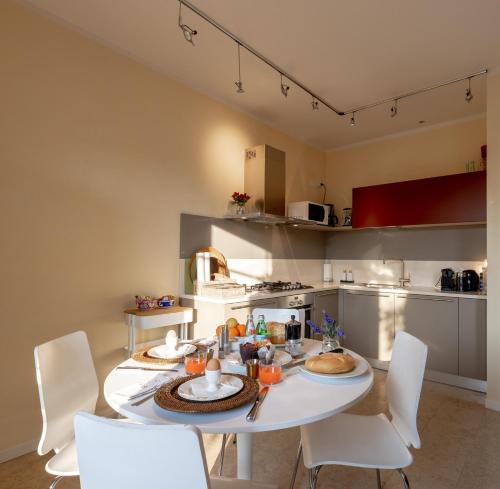 a kitchen with a white table and white chairs at Casa Bembo in Asolo