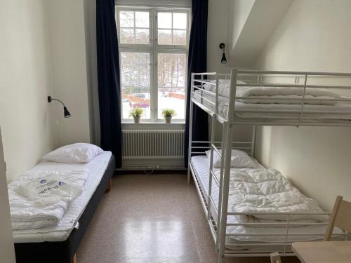 two bunk beds in a room with a window at Ronneby Brunnspark Vandrarhem och B&B in Ronneby