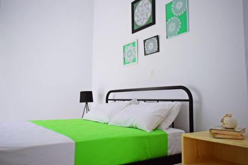 Un dormitorio con una cama con una manta verde. en Filia's Family Apartment, en Archangelos