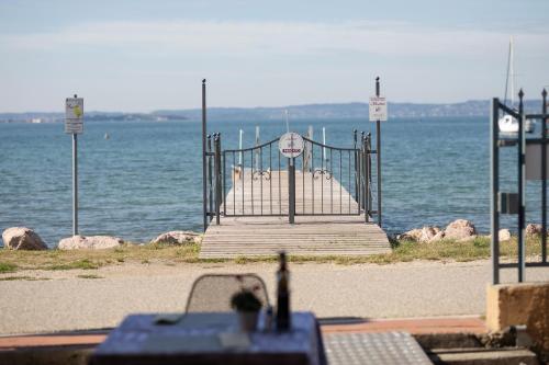 a gate on the beach near the water at Locanda Le Palafitte in Bardolino