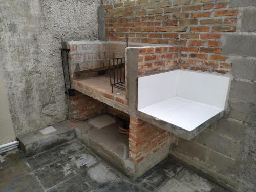 a brick wall with a white shelf on it at Casita de Piedra in Trinidad