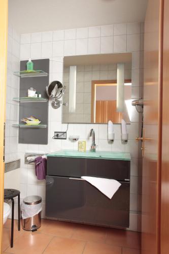 a bathroom with a sink and a mirror at Eden Hotel in Bad Krozingen