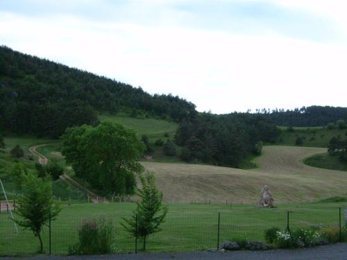 a field of grass with a fence and trees at Chez Louis chambres d'hôtes à la ferme in La Canourgue
