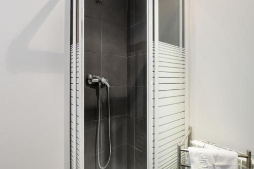 a shower in a bathroom with black tiles at Studio at Arinsal 100 m away from the slopes with wifi in Arinsal