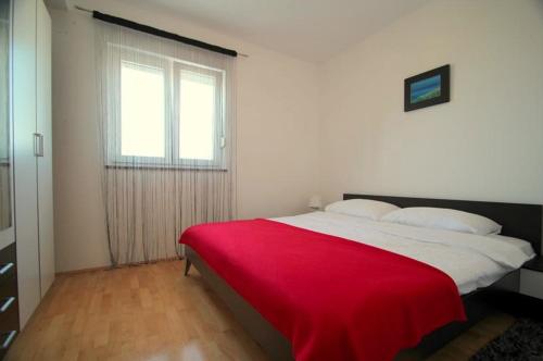 sypialnia z dużym łóżkiem i czerwonym kocem w obiekcie 4 Star apartments with sea view in Zambratija w mieście Zambratija