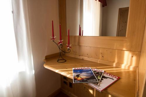 a counter with two red candles and a book on it at Hotel Alpi - Asiago in Asiago
