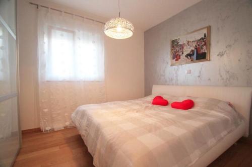 a bedroom with a bed with red pillows on it at 4 Star app Adriana with sea view and jacuzzi in Zambratija