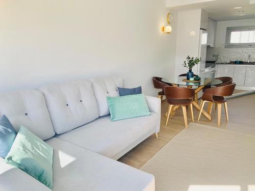 a living room with a white couch and a table at Apartamento con solarium Villa Amalia in Torrevieja