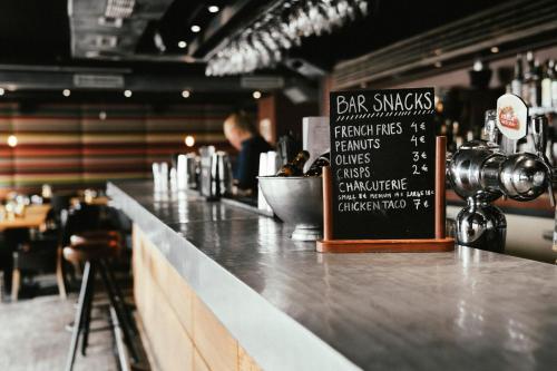 a bar with a counter with a chalkboard on it at Langley Hôtel Victors in Val dʼIsère