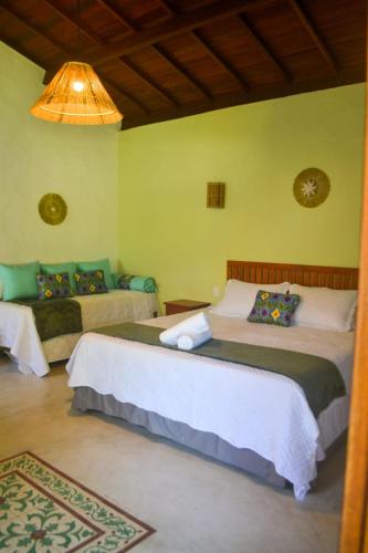 a bedroom with two beds and a chandelier at Vila Sol Chalés in Pôrto de Pedras