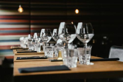 a row of wine glasses on a wooden table at Langley Hôtel Victors in Val dʼIsère